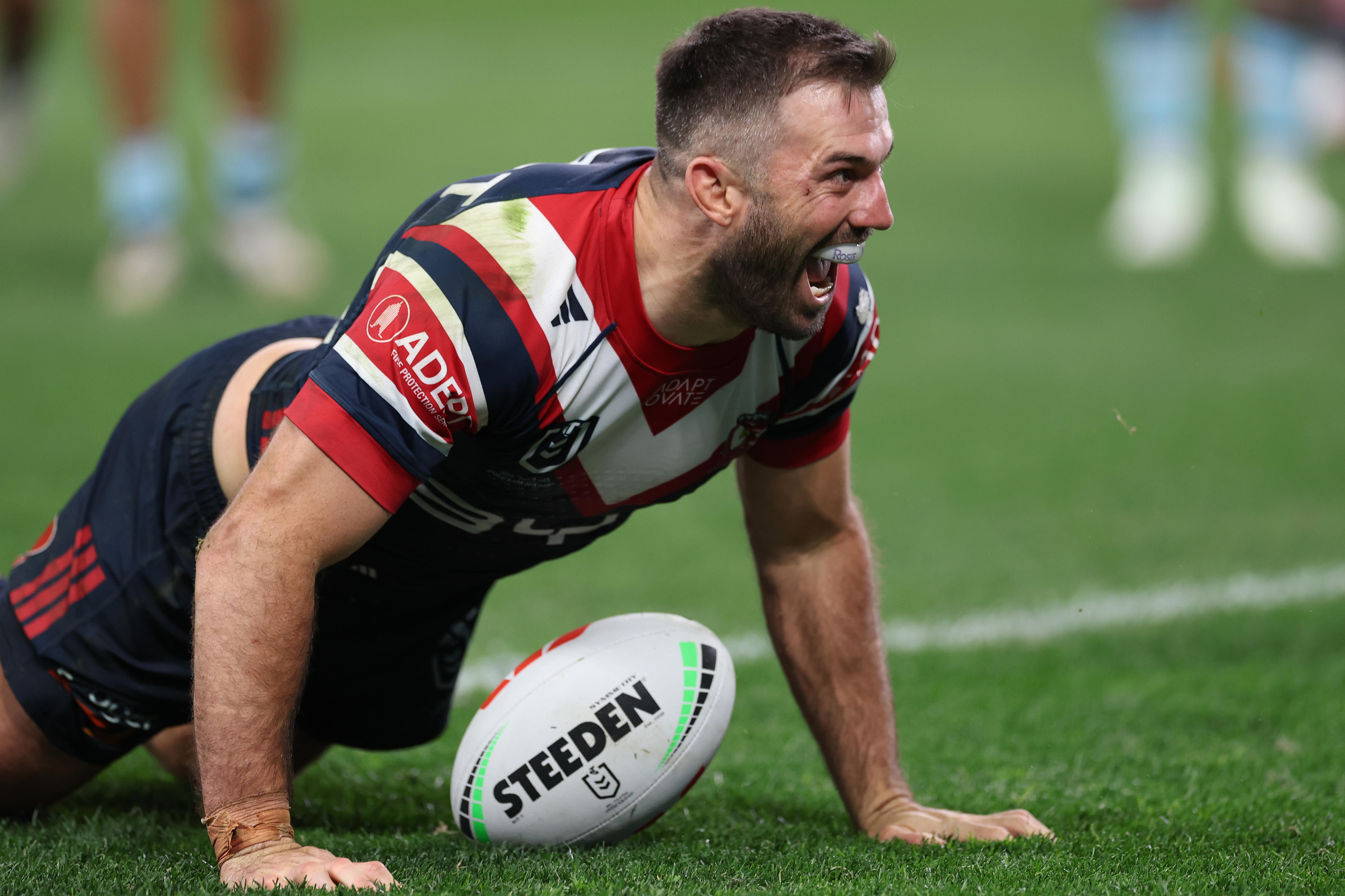 A man celebrates scoring a try in a rugby league match 