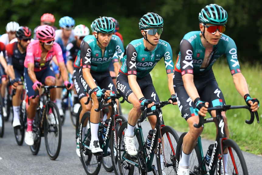 Bora-Hansgrohe riders in grey kit ride in a line