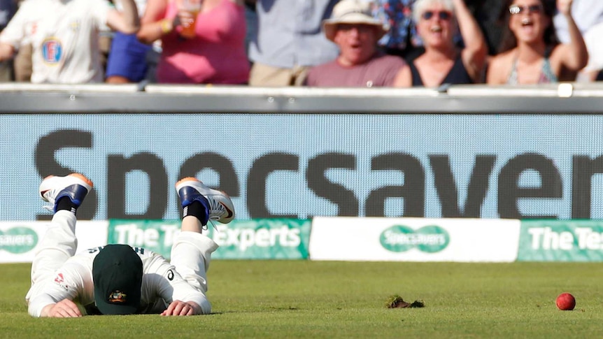 Australia' Marcus Harris puts his face in the grass after dropping a catch in the third Ashes Test at Headingley. Fans cheer.