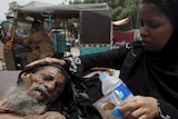 Woman wiping forehead of her father in Pakistan