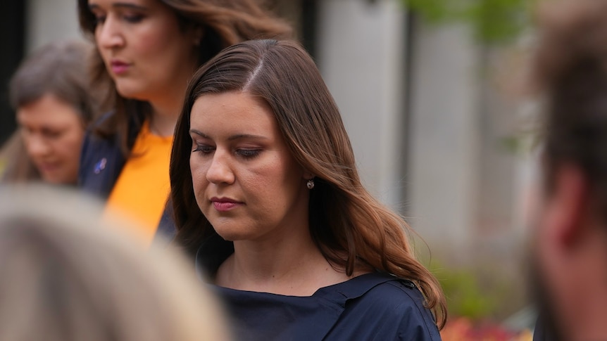 Brittany Higgins walking into the ACT court with her head down.