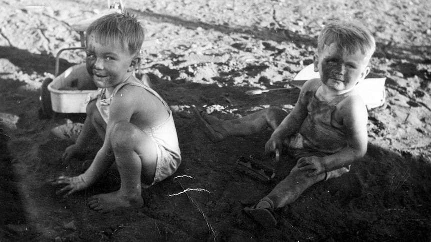 Two boys play in a pit of asbestos 