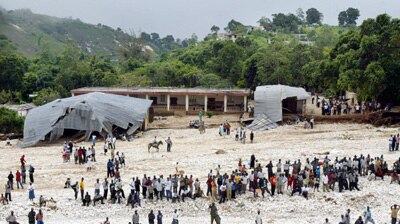 People in Haiti stand in the riverbed near a destroyed church and school. (File photo)