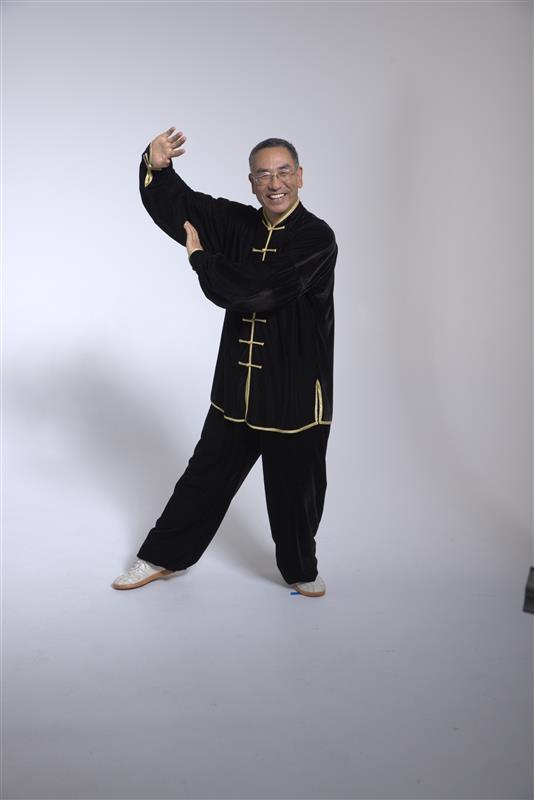 Hombre con uniforme de Tai Chi haciendo movimientos de Tai Chi. 