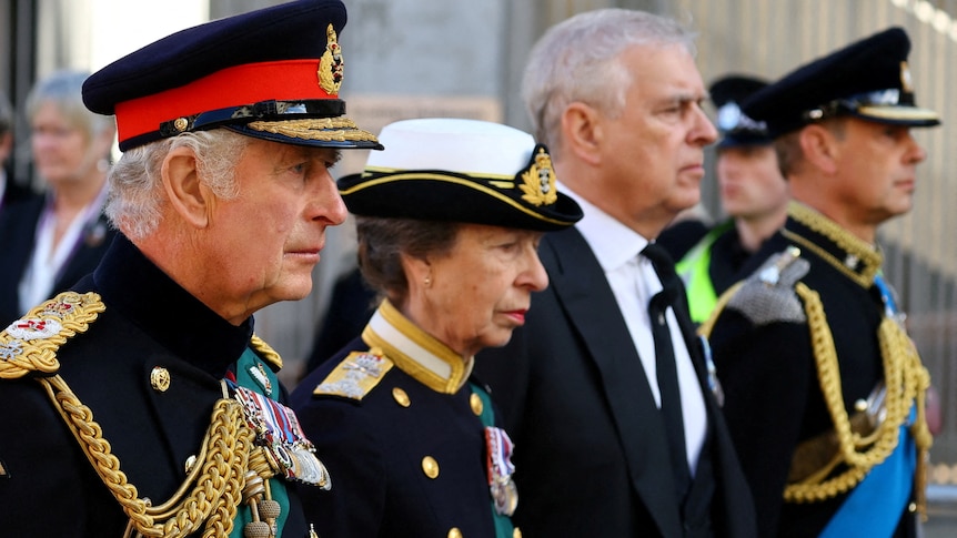 King Charles, Princess Anne and Prince Edward stare ahead dressed in military uniform next to Prince Andrew in a suit