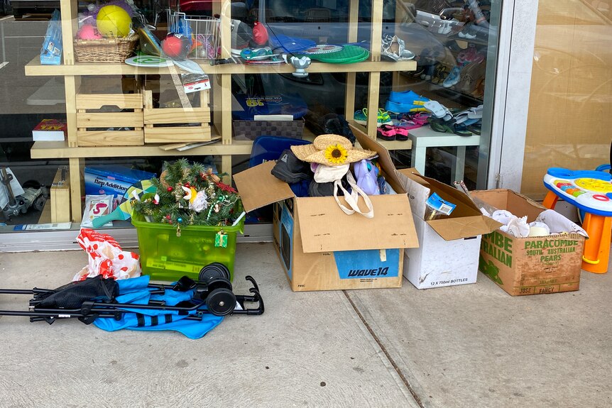 A range of items and boxes sitting outside a shop window