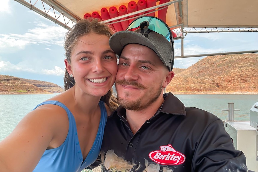 A woman and a man embrace and smile at a camera together