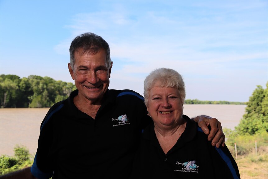 Bob Richards and Julie Tyson smile in front of a river.