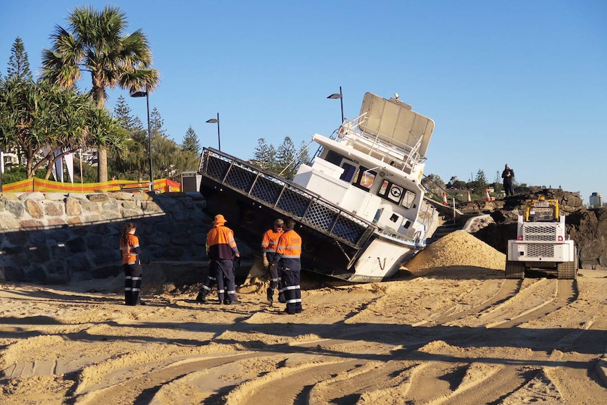 Workers assess how to move spanner crab fishing boat Matahati run aground on Mooloolaba Beach