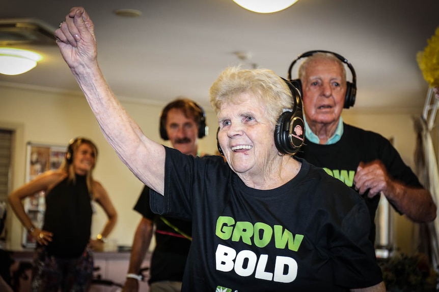 Woman with headphones on and hand raised