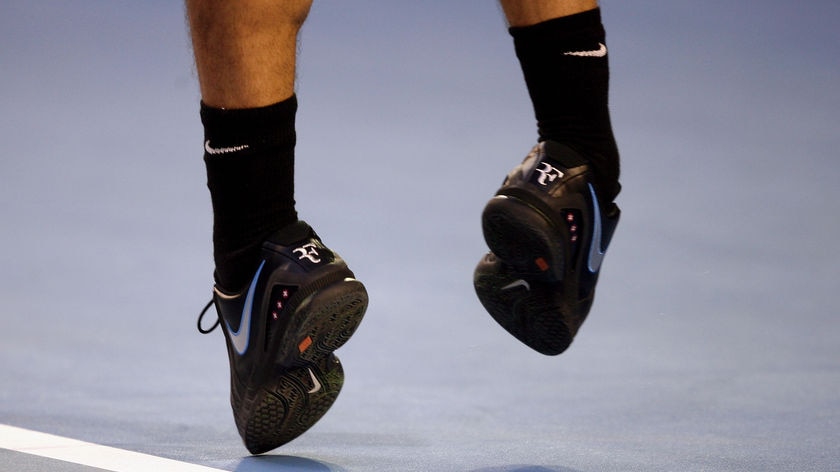 The feet of Roger Federer of Switzerland leave the ground as he serves during his quarter-final match against James Blake of the United States on day 10 of the Australian Open at Melbourne Park, January 23, 2008.