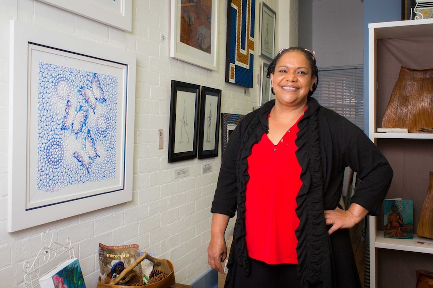 Elsie Randall stands next to a painting.