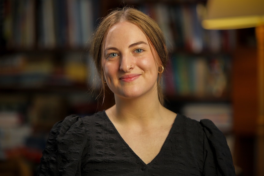 Woman wearing a black top smiling for a portrait.