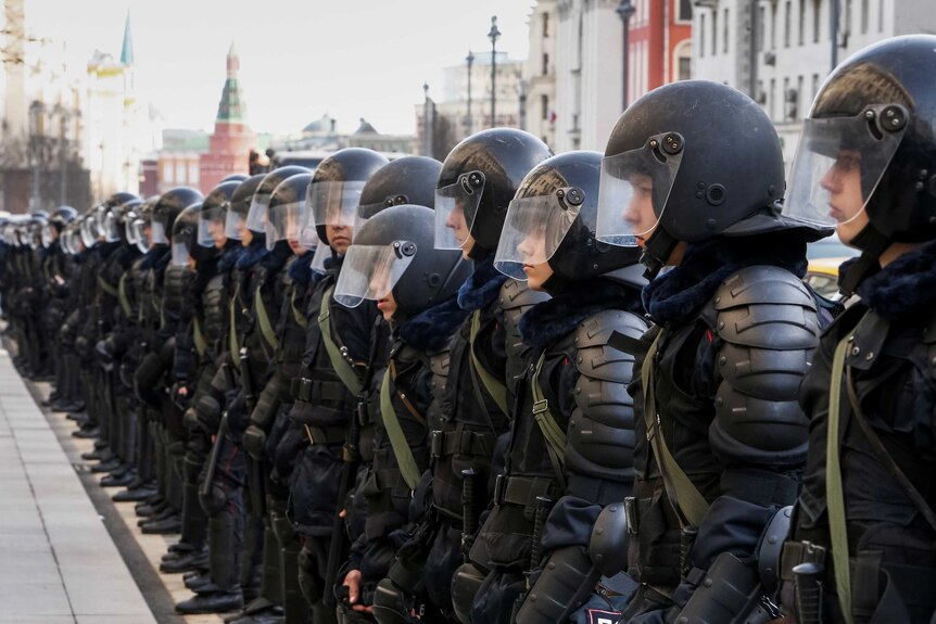 Riot police line up along a street as they block a rally in Moscow.