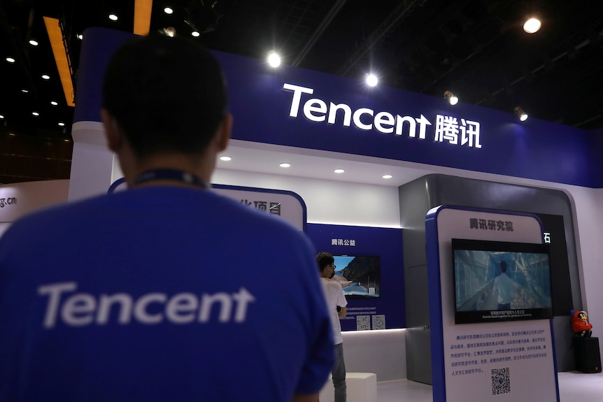 A staff member is seen at a booth of Tencent at an exhibition