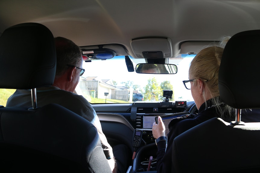 clinical nurse consultant Simon Daniels and Queensland Police Sergeant Megan Ward in a police car at Logan.