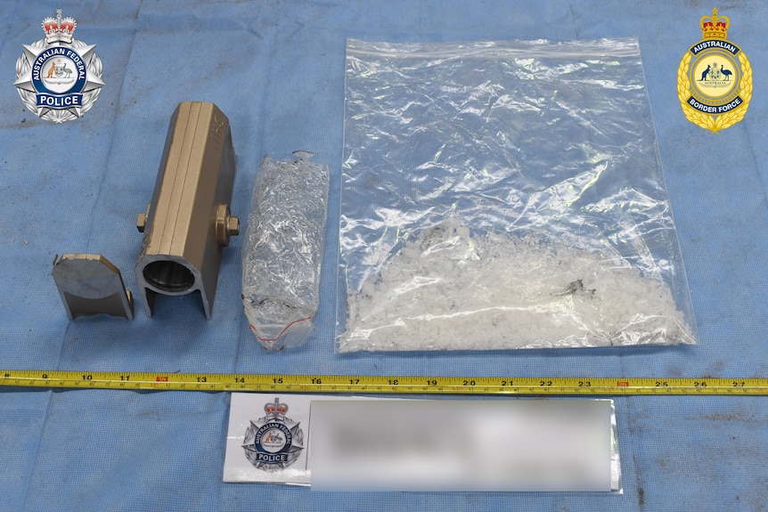 A bag of methamphetamine on a table with a measuring tape