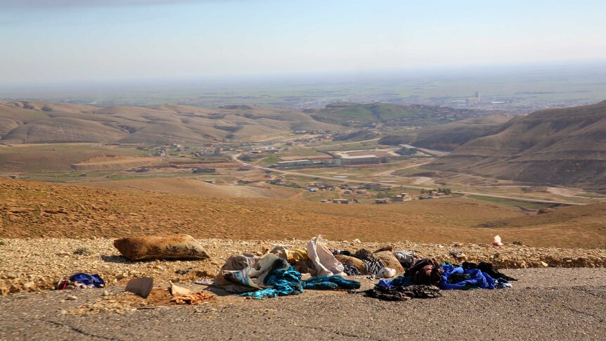 Yazidi clothes lay scattered on the road overlooking Sinjar were thousands fled IS forces