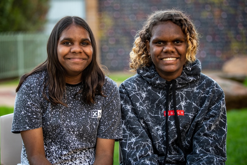 Two young native girls sitting next to each other