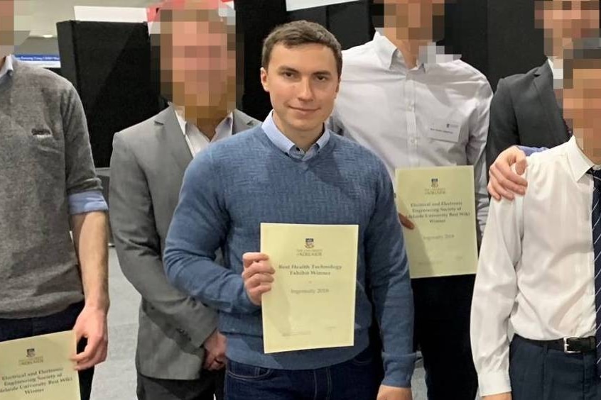 A group of people hold up university certificates.