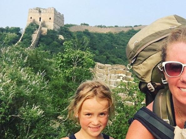 A selfie photo of a mother backpacking with her daughter on the Great Wall of China.