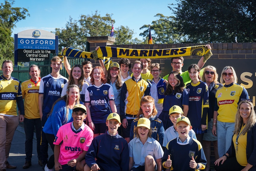 High school students wearing yellow and navy coloured clothes in support of their local sport team.
