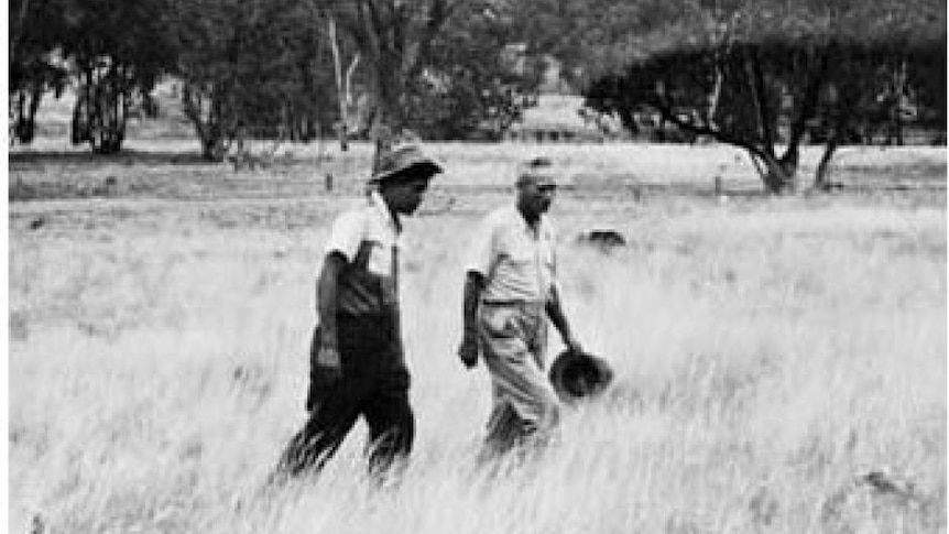 Black & white photo of Aboriginal tracker Alexander Riley and colleague walking through the bush