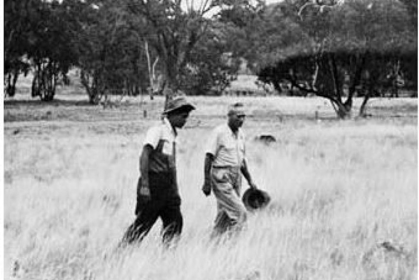 Black & white photo of Aboriginal tracker Alexander Riley and colleague walking through the bush