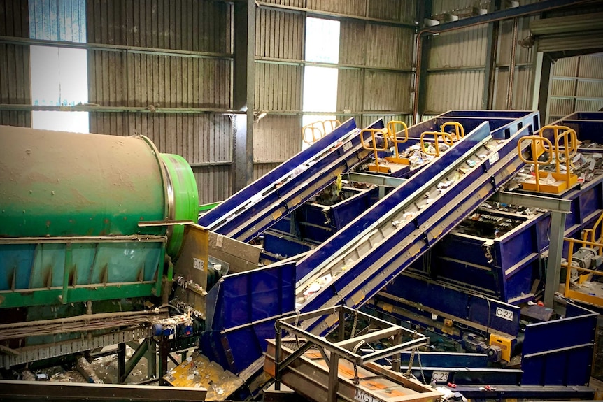 A recycling plant with waste travelling along conveyer belts.