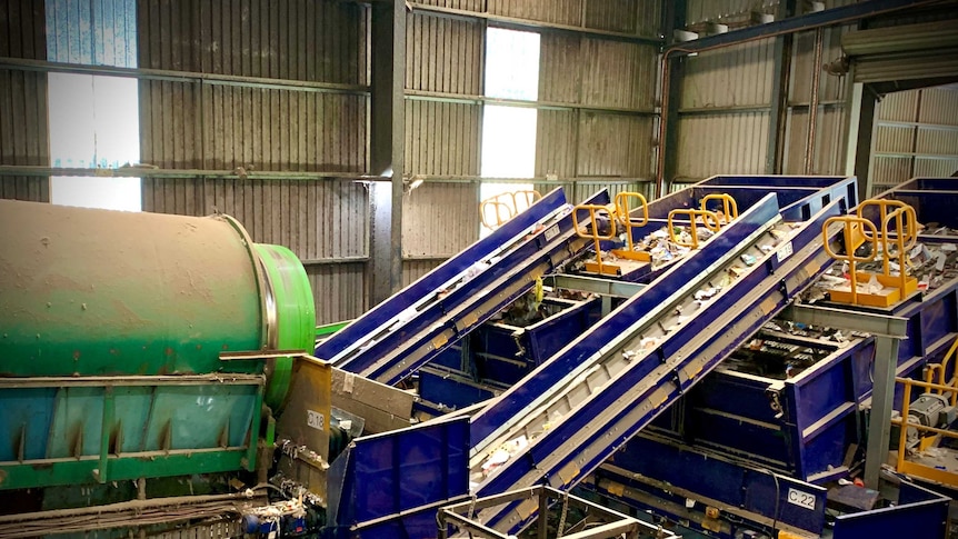 A recycling plant with waste travelling along conveyer belts.