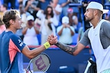 Alex de Minaur and Nick Kyrgios shake hands across the net after a match at the Montreal Masters ATP tennis tournament.