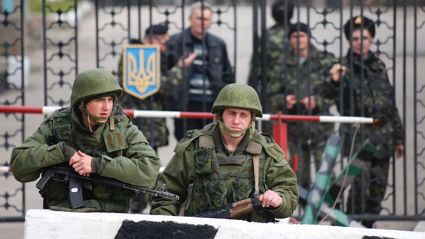 Russian soldiers stand outside Ukrainian military post