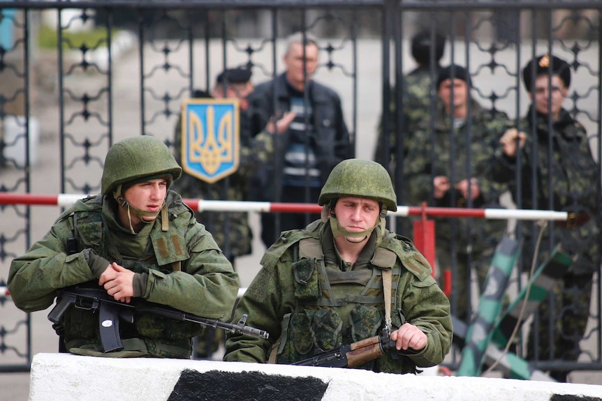 Russian soldiers stand outside Ukrainian military post