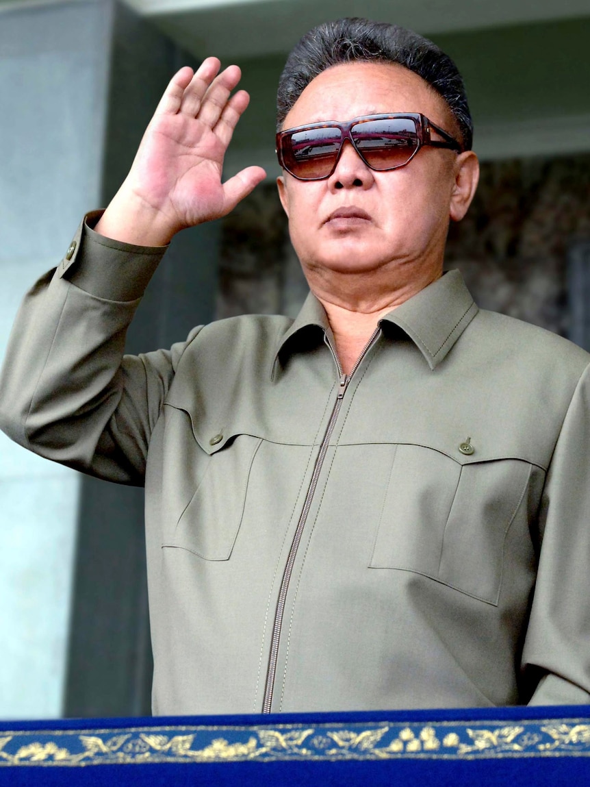 Kim Jong-il looks at soldiers taking part in a military parade.