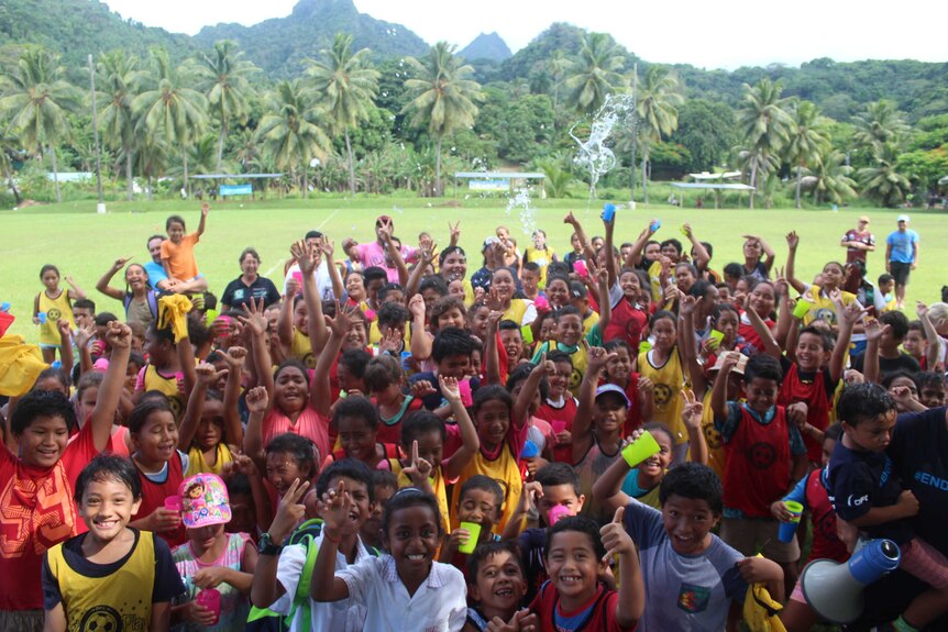 A large group of children pose for a photo as part of Just Play at Tupapa