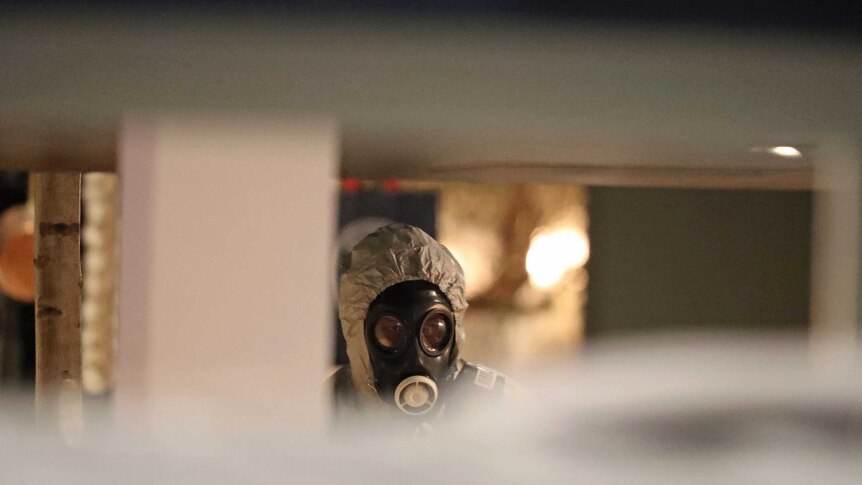 Investigators wear gas masks as they examine the restaurant