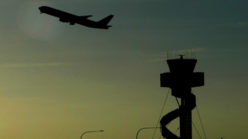 Passenger plane and air traffic control tower at Sydney airport