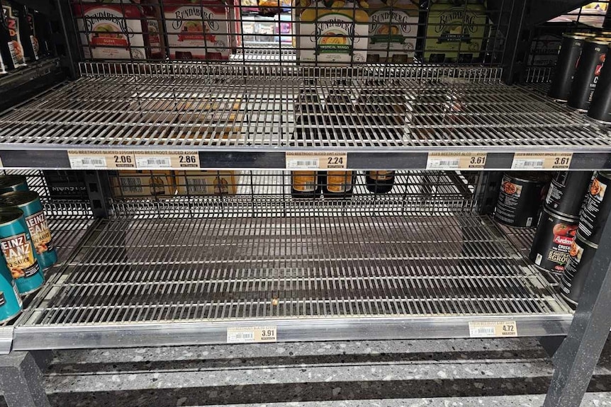 an empty supermarket shelf showing beetroot can labels