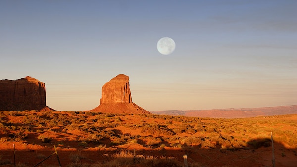 A full moon rises over Monument Valley Navajo Tribal Park