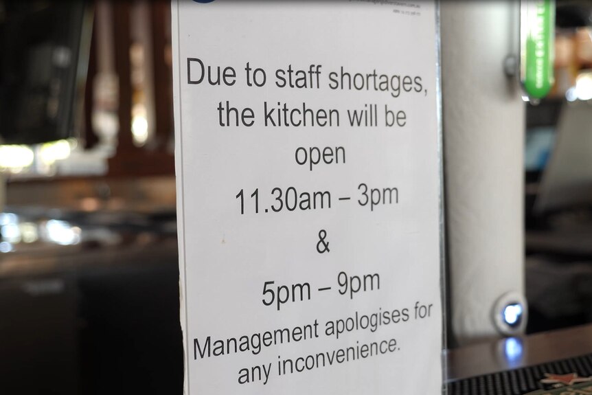 A sign reads "due to staff shortages the kitchen will be open 11:30am - 3pm and 5pm-9pm"