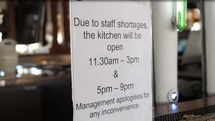 A sign reads "due to staff shortages the kitchen will be open 11:30am - 3pm and 5pm-9pm"