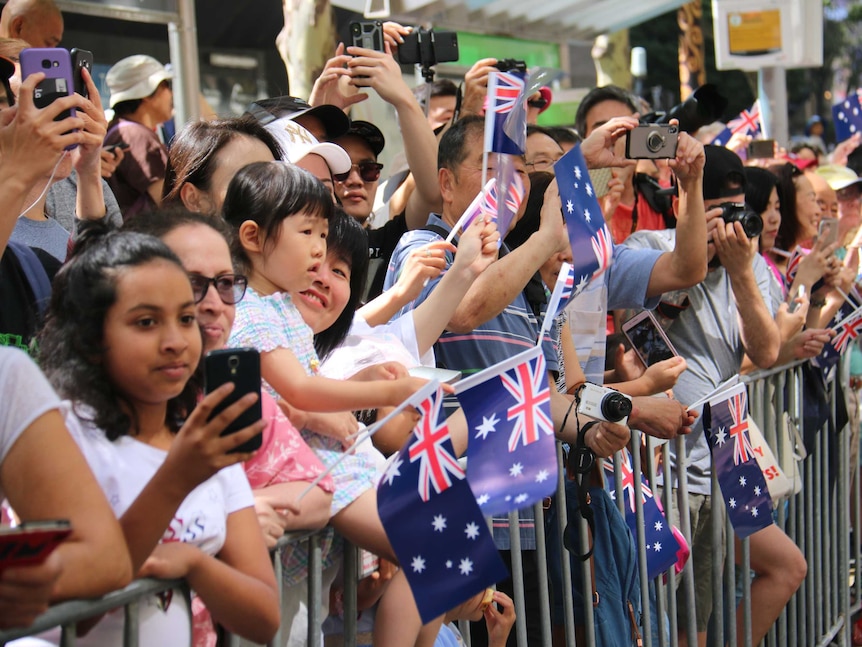 人群挥舞着澳大利亚国旗观看游行。