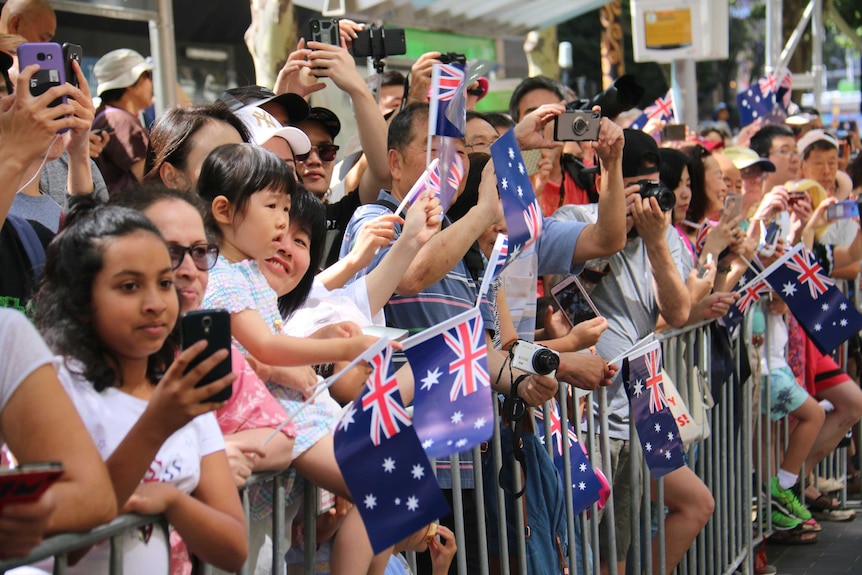 人群挥舞着澳大利亚国旗观看游行。