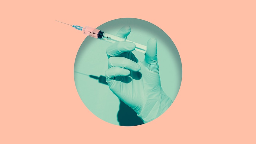 Doctor's hand holding syringe of COVID vaccine placed inside round hole in pink paper.