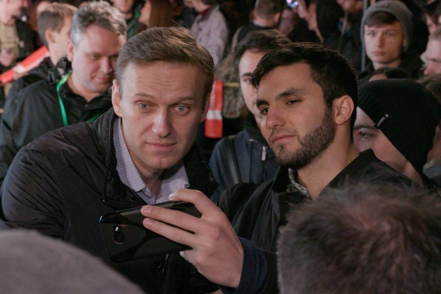 Alexei Navalny takes a selfie with a supporter in the crowd