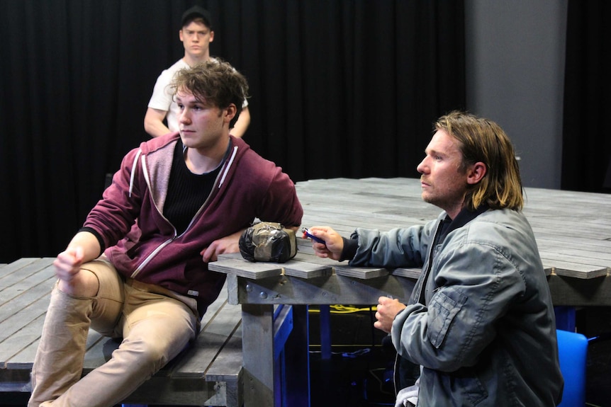 Two male characters on stage during a rehearsal.