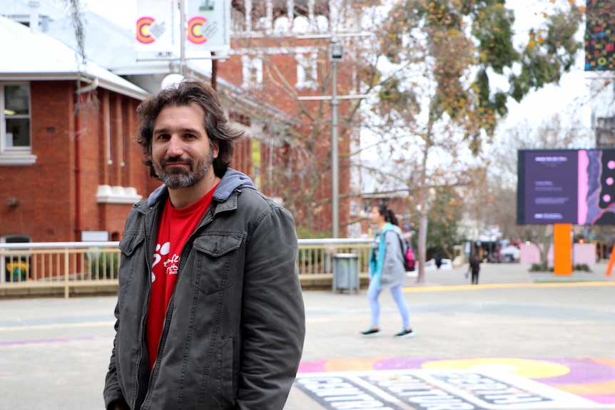 Man standing in a open space in the city.