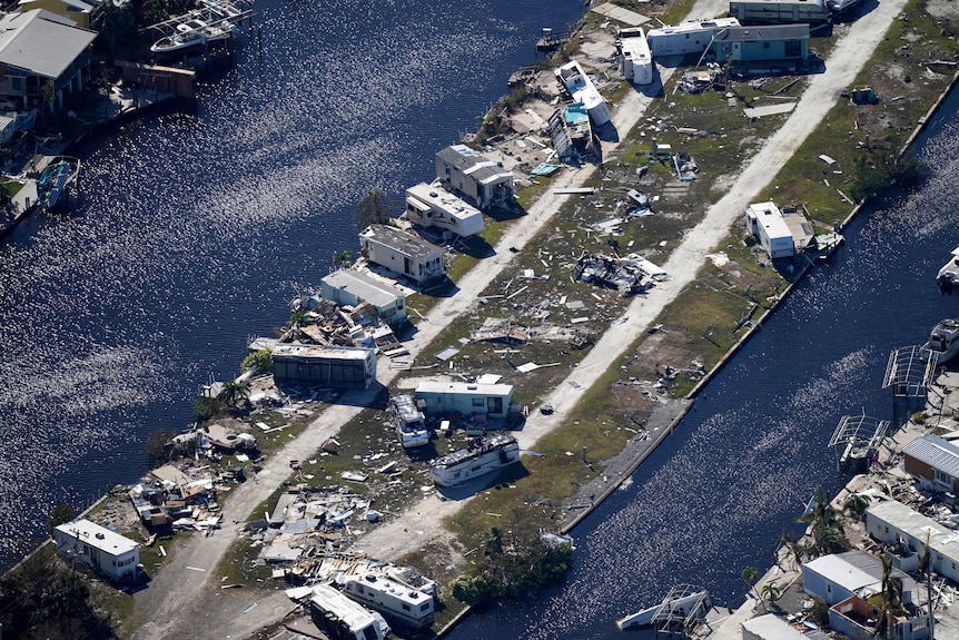 Houses along the coast lay in piles of debris near the water.
