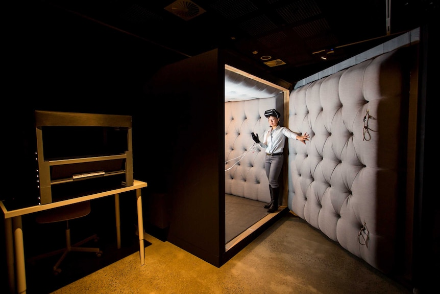 The artist Eugenie Lee invites you into a padded room, she has a glove and VR headset on