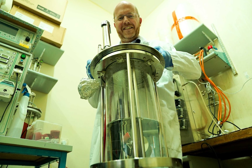 A man standing over machinery used to ferment sweet proteins